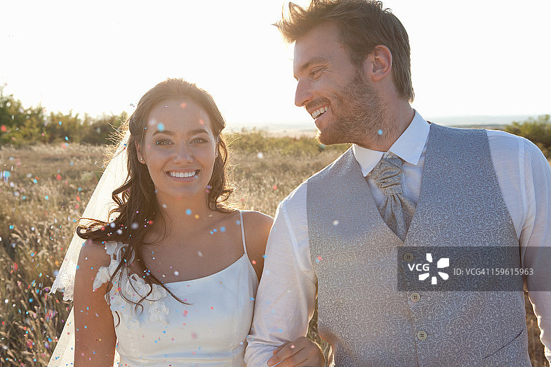 新婚夫妇在五彩纸屑中行走图片素材