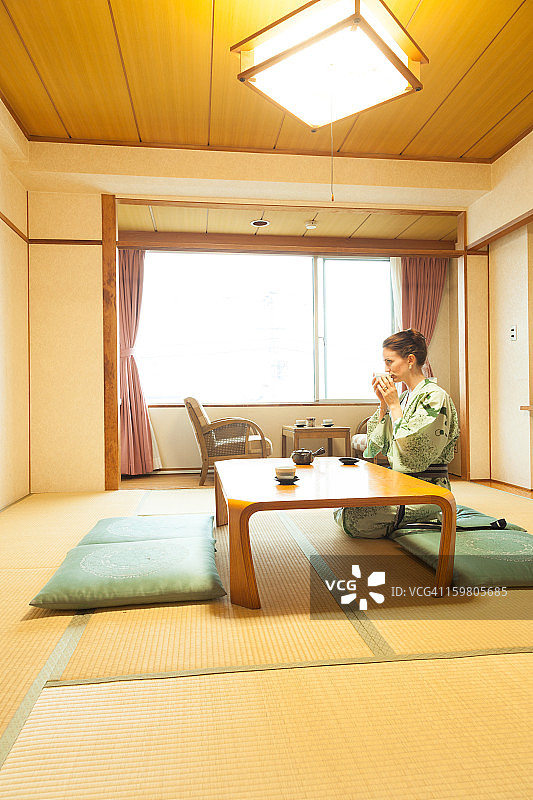 在传统日式房间里喝茶的女人图片素材