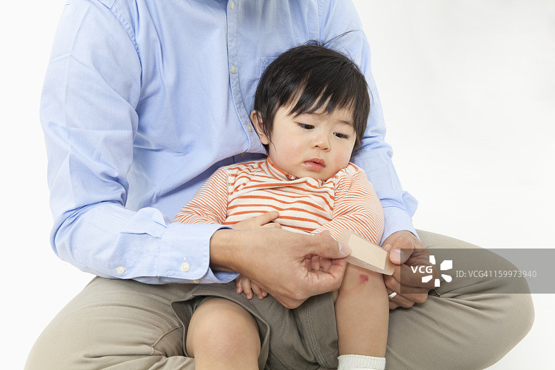 父亲给儿子的膝盖贴创可贴图片素材