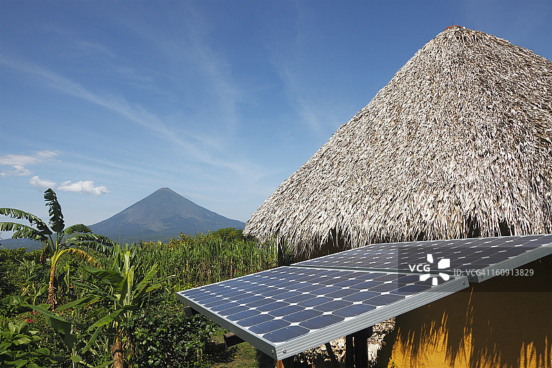 太阳能板、茅草屋顶与康塞普西翁火山图片素材
