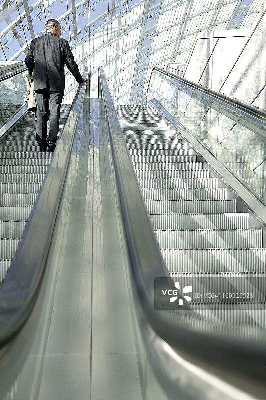 商务人士在自动扶梯上的背影图片素材