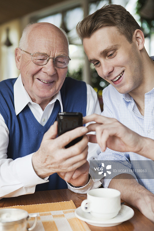 老人和年轻男人使用手机图片素材