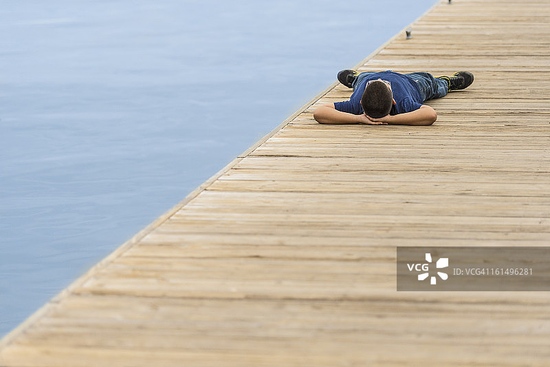 躺在坦帕湾码头上的十岁男孩图片素材