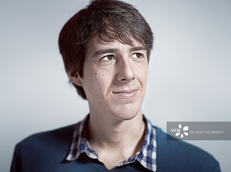 身穿蓝色套头衫的男人抬头侧视图片素材