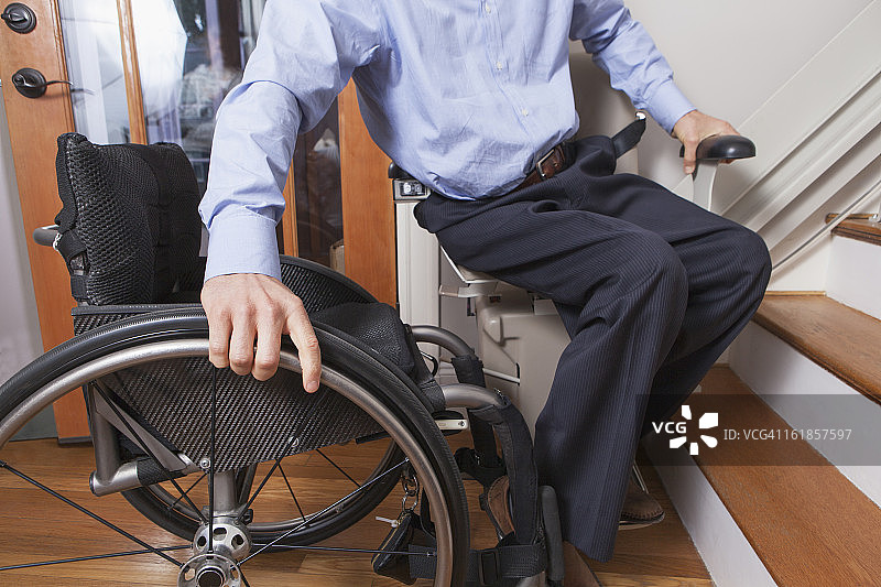 脊髓损伤男子乘坐电动楼梯升降机图片素材