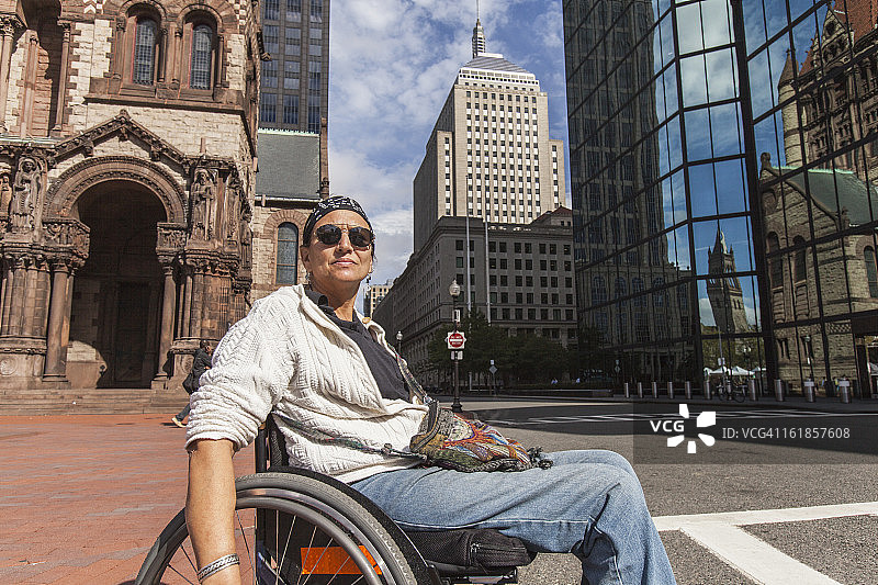 脊髓受伤的女人穿过街道，圣詹姆斯大街，约翰·汉考克大厦，三一教堂，波士顿，马萨诸塞州，美国图片素材