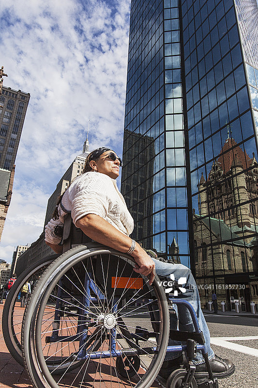 脊髓受伤的女人穿过街道，圣詹姆斯大街，约翰·汉考克大厦，三一教堂，波士顿，马萨诸塞州，美国图片素材