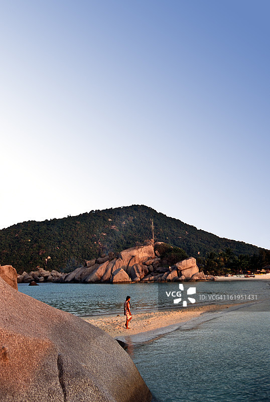 傍晚时分，女人在沙洲上行走图片素材