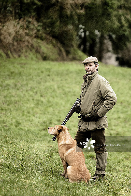 看着镜头的游戏管理员和狗图片素材