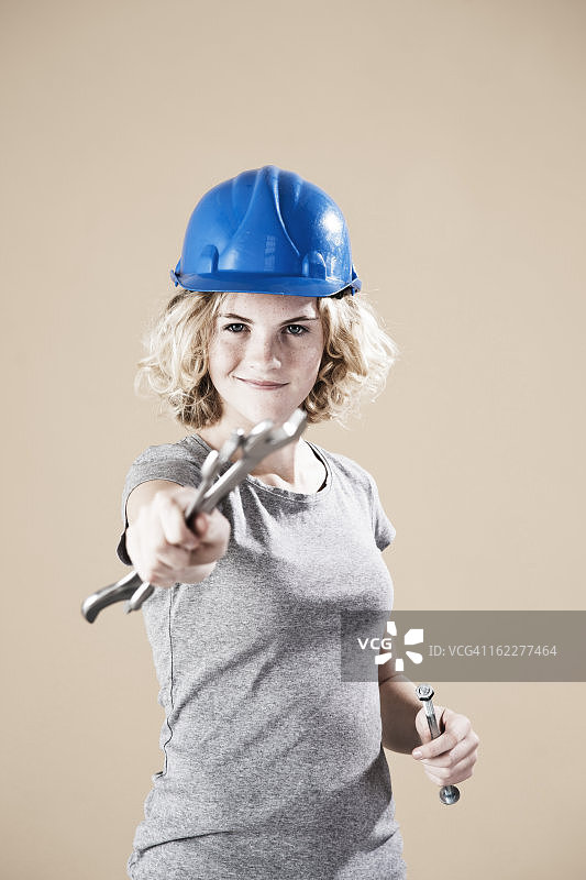 十几岁的女孩，戴着头盔和拿着手工具图片素材