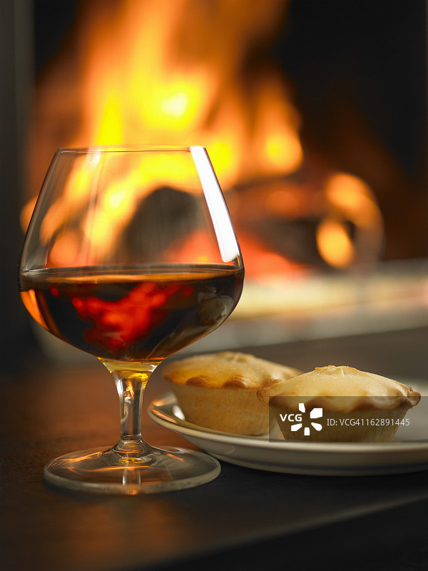 炉火旁的白兰地和肉馅饼图片素材