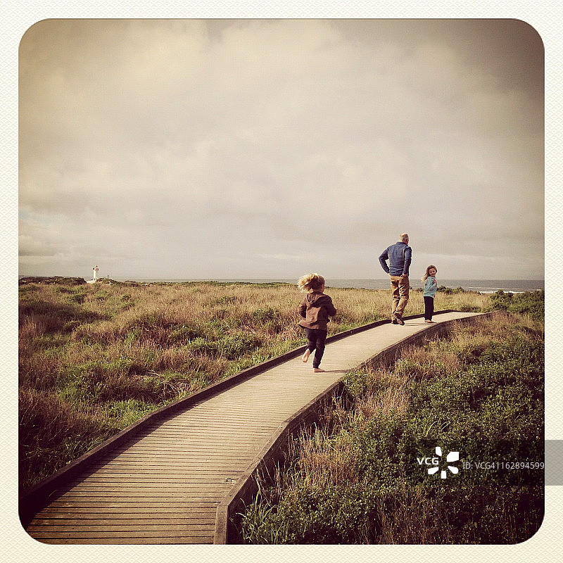 孩子们和祖父在沿海小路上行走图片素材