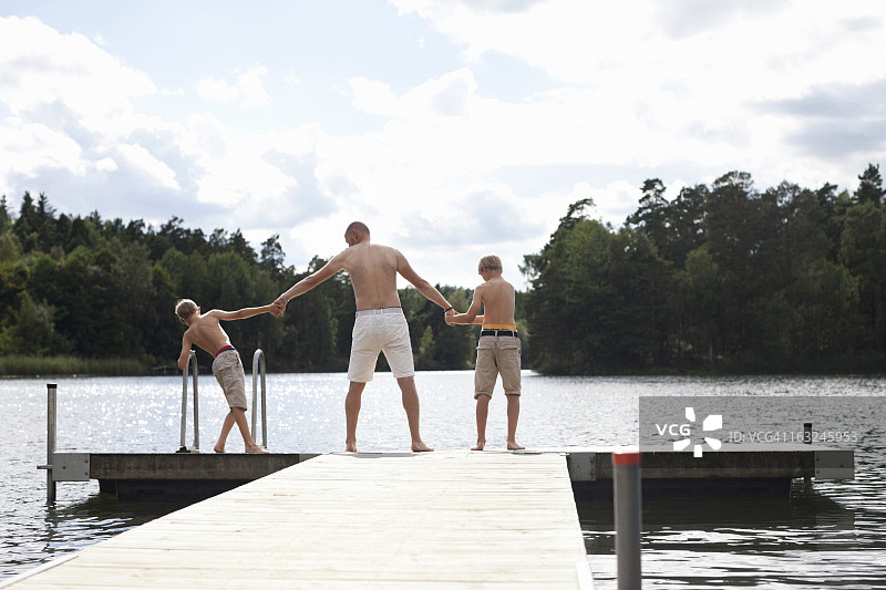 父子在木板路边缘的后视图图片素材