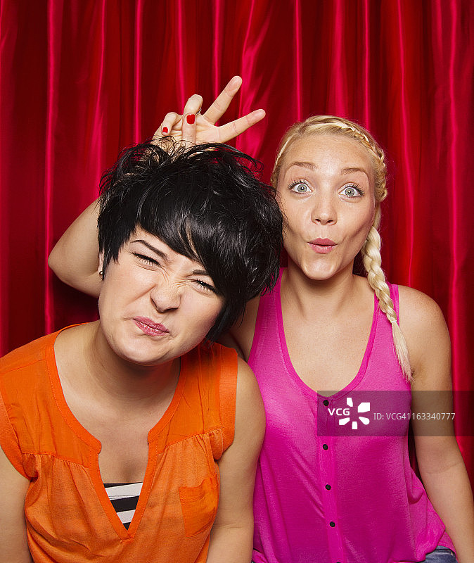 年轻女人在照相亭里做鬼脸图片素材