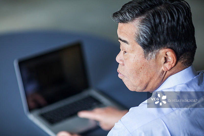 一位年长的企业高管望着窗外沉思图片素材