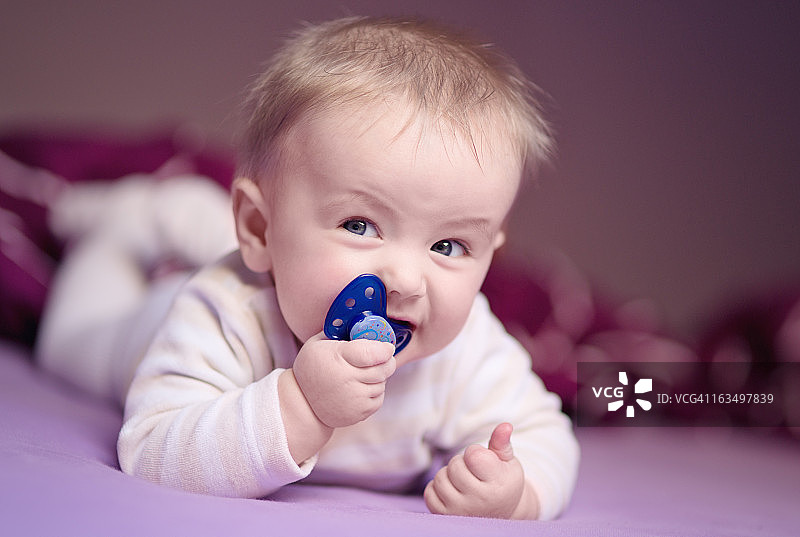 含着奶嘴，竖起大拇指的婴儿图片素材