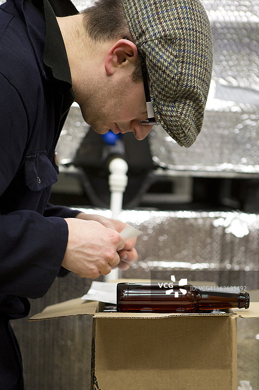 啤酒厂技术员在啤酒瓶上贴标签图片素材