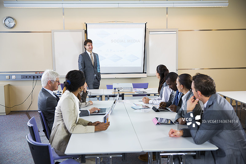 商务会议：使用数字投影仪的讲师图片素材