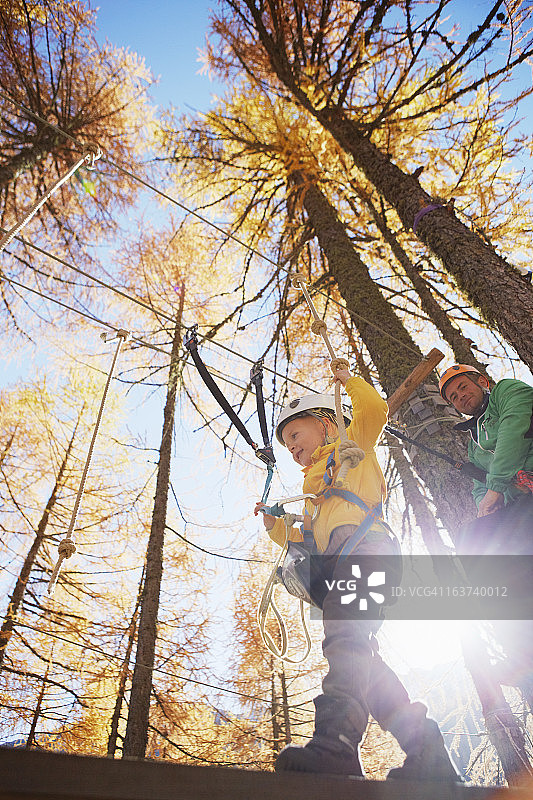 在高空绳索课程中保持平衡的男孩图片素材