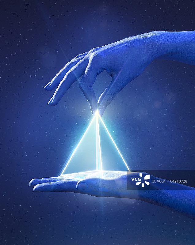 蓝色手捏着发光的光棱镜图片素材