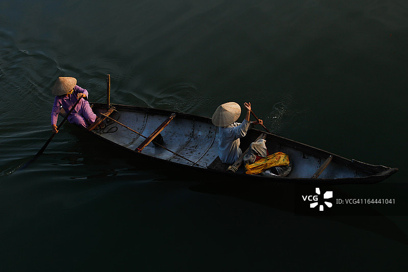 戴着锥形帽的越南妇女在船上图片素材