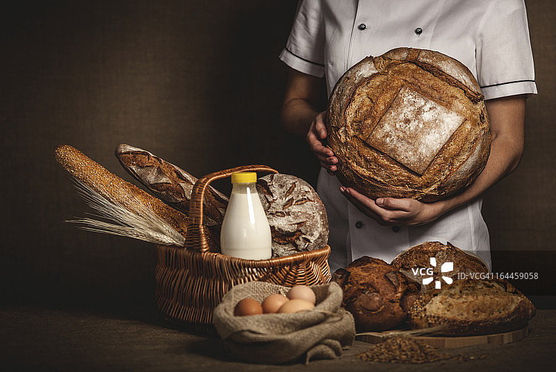 面包师手捧新鲜出炉的面包图片素材