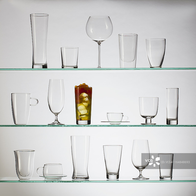 装满珍珠奶茶的玻璃杯，周围放着一堆空玻璃杯图片素材