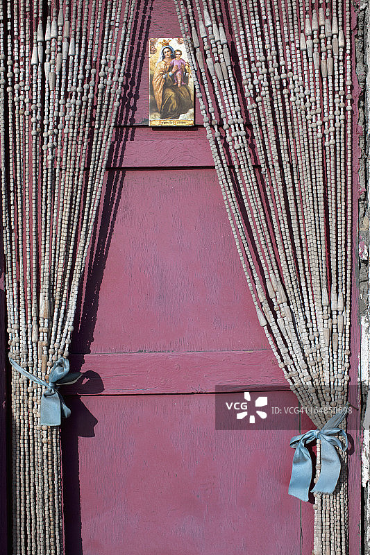 圣母玛利亚和耶稣宝宝的圣像卡挂在串珠门帘上图片素材