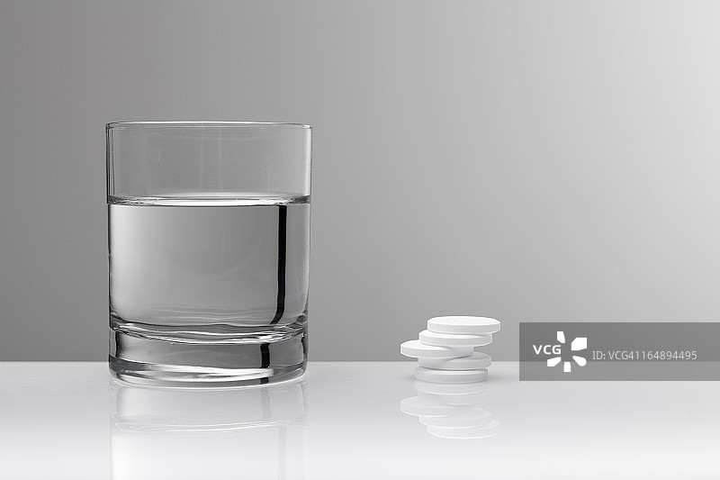 阿司匹林扑热息痛药丸和一杯水图片素材