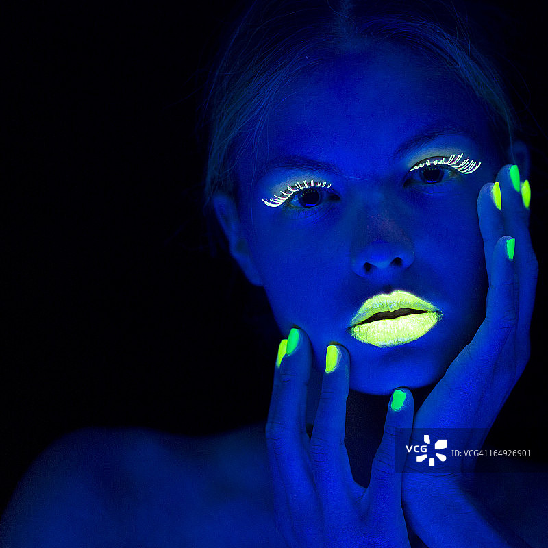 霓虹灯下拥有石灰绿指甲的女士肖像图片素材