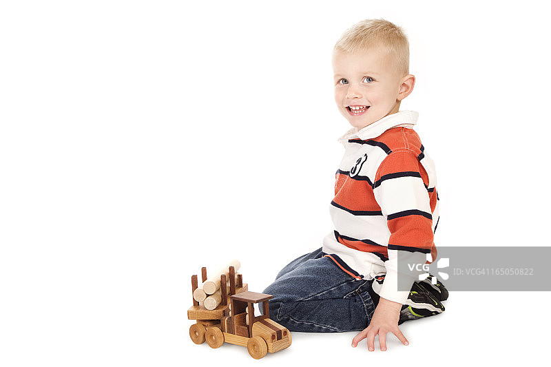 3岁男孩玩他的新木制卡车图片素材