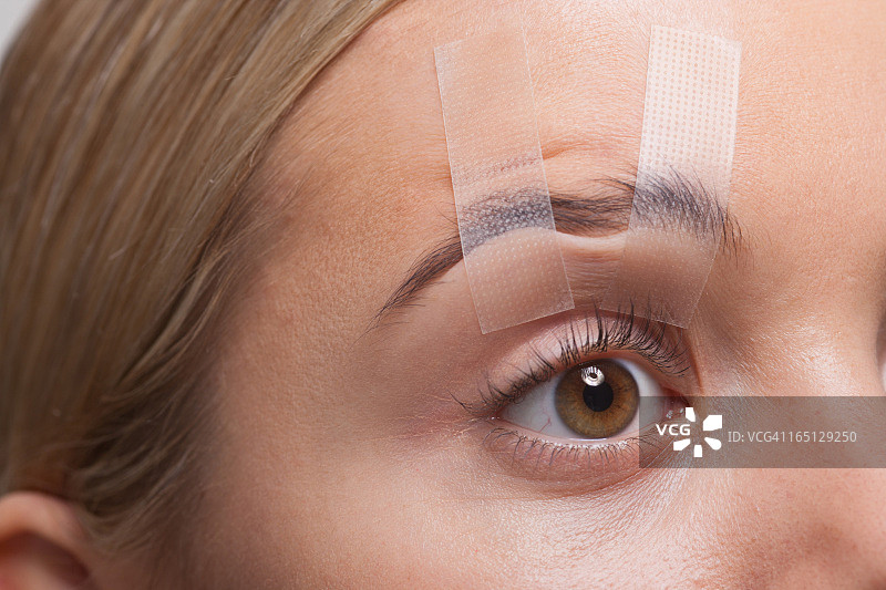 用胶带撑开的女性眼睛特写图片素材