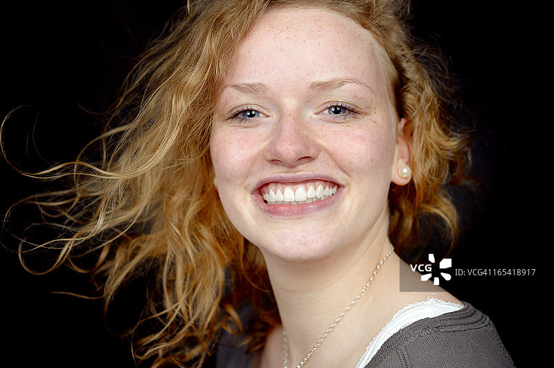 快乐的女孩，带着灿烂的笑容和飘逸的头发图片素材