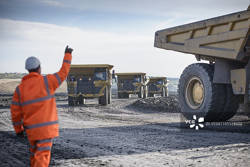 煤矿工人向矿用自卸车挥手图片素材