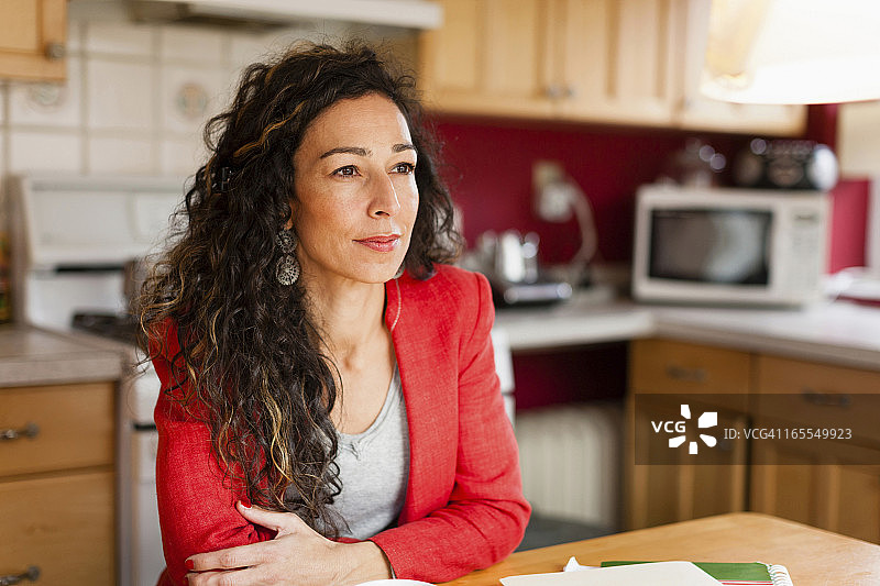 微笑的女人坐在厨房里图片素材