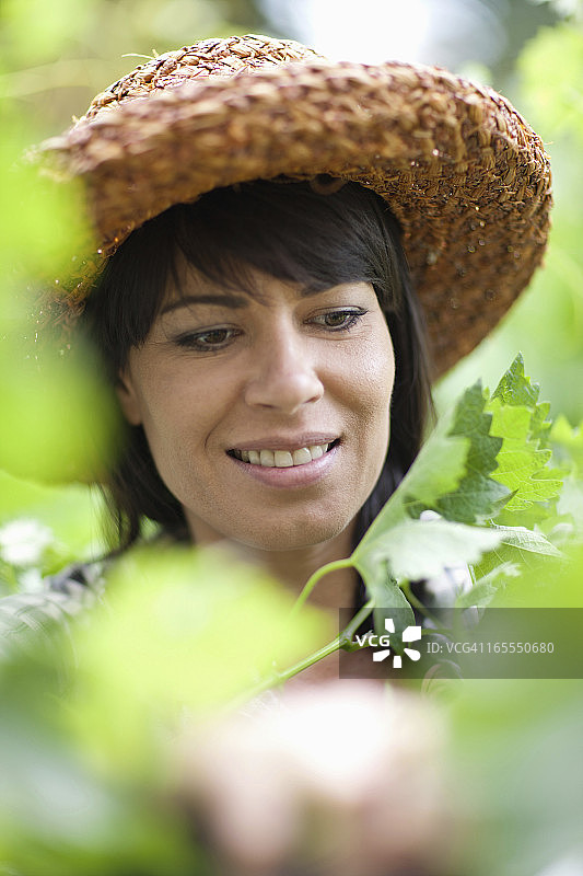 站在高大植物中的微笑女人图片素材