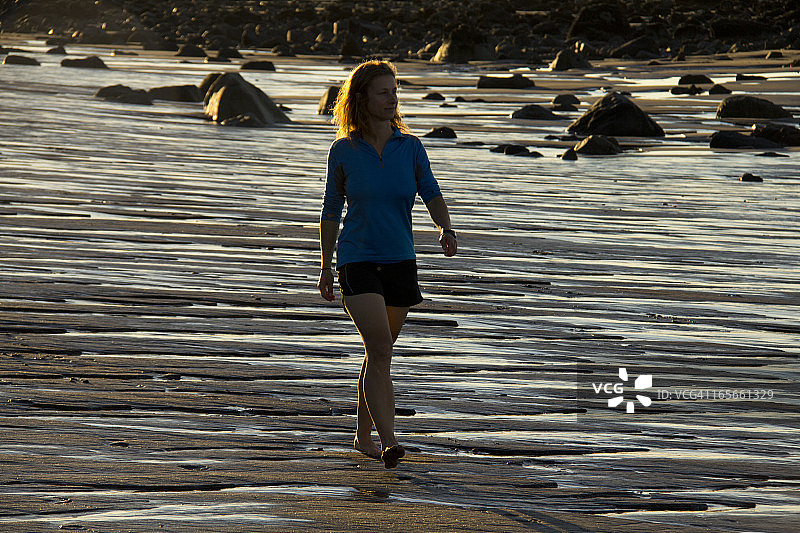 女人走在新西兰海滩上图片素材