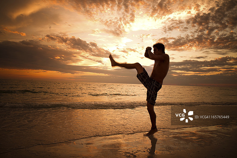 日出时分的武术家踢腿图片素材