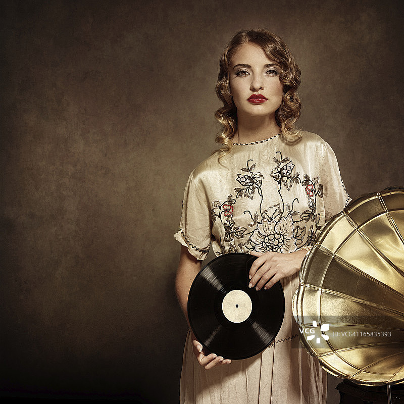 听着音乐，拿着旧黑胶唱片的女人图片素材