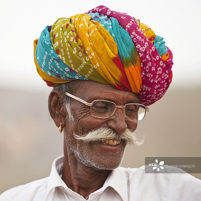 戴着彩色头巾和眼镜的年长印度人微笑图片素材