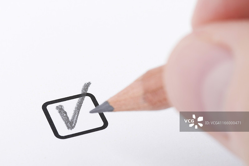 手持铅笔书写“勾号”图片素材