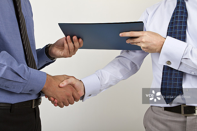 两位商人手持文件握手图片素材
