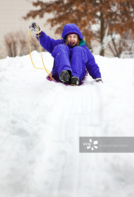 兴奋的年轻女孩玩雪橇图片素材