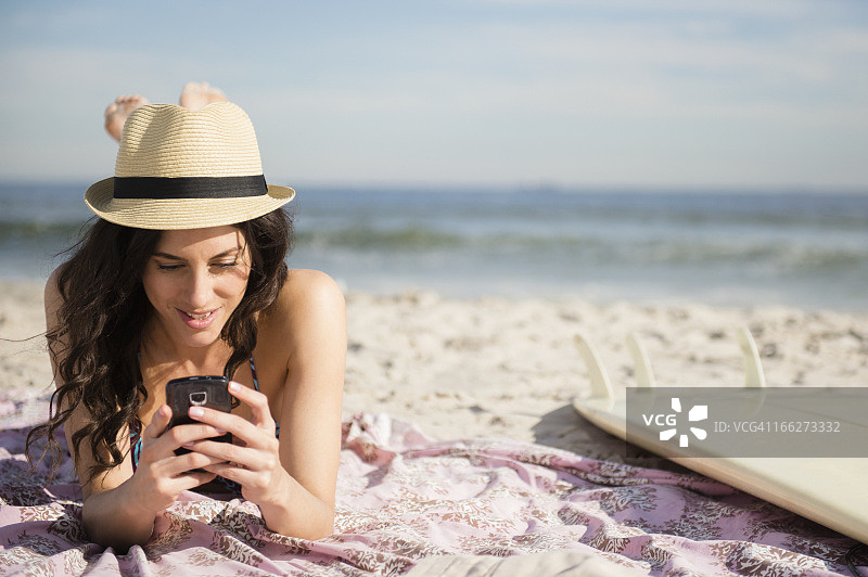 美国纽约州洛克威海滩：女子在海滩上使用手机图片素材