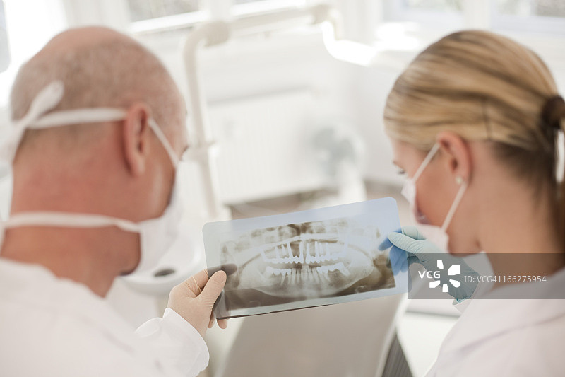 德国巴伐利亚兰茨贝格牙医和女牙医助理展示X光片图片素材