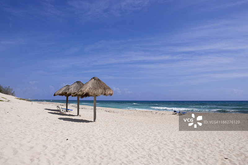 墨西哥科苏梅尔热带海滩上的沙滩椅和棕榈小屋图片素材