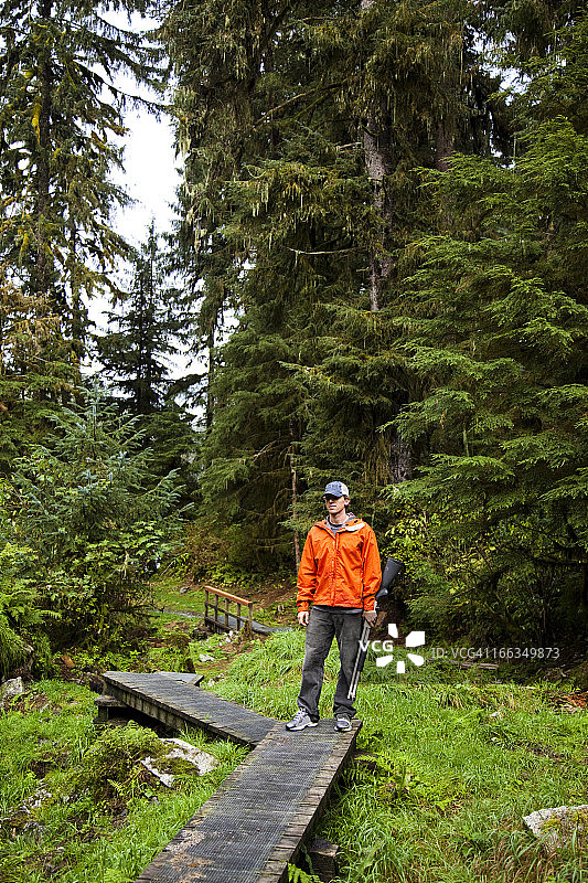 男人手持霰弹枪，木栈道上图片素材