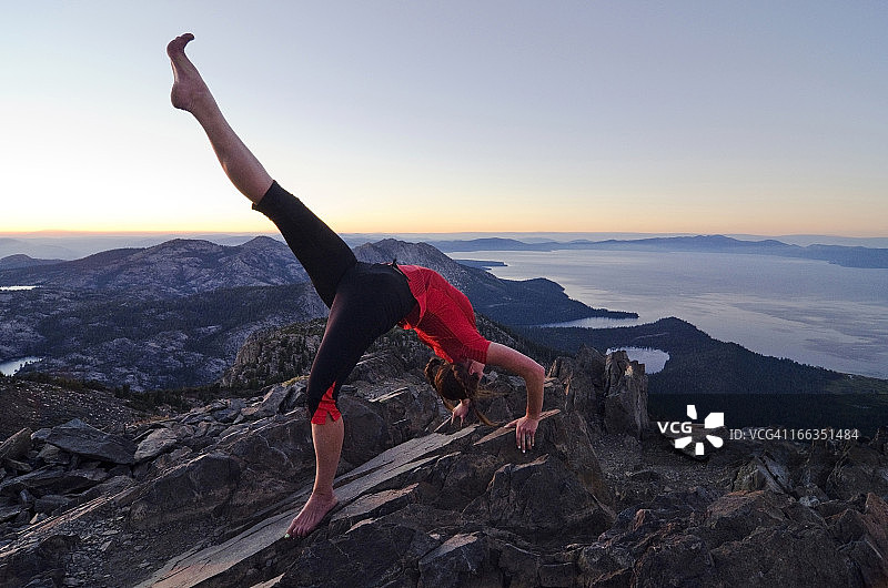 日落时分，女人在塔拉克山顶上做瑜伽，背景是太浩湖，加利福尼亚州图片素材