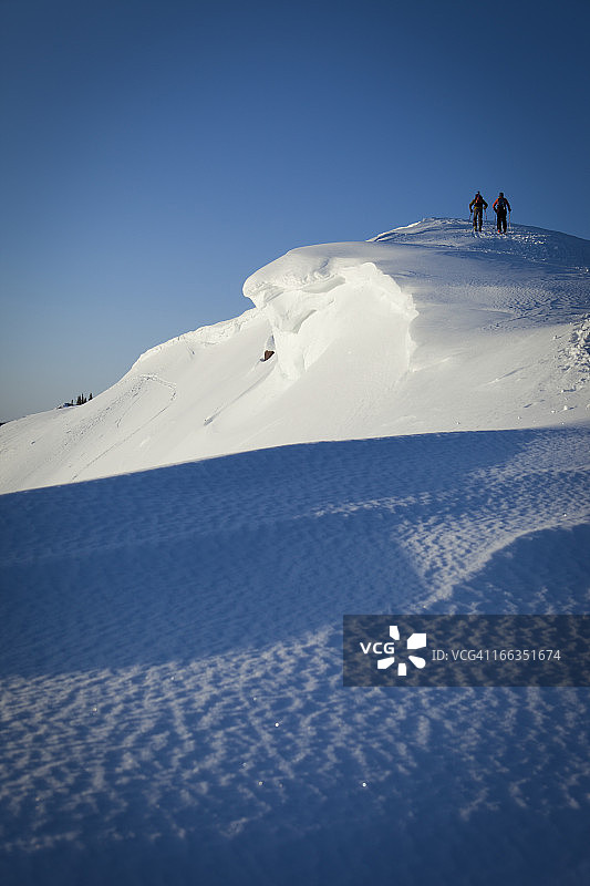 紫色日出时分在山上滑雪的人的剪影图片素材