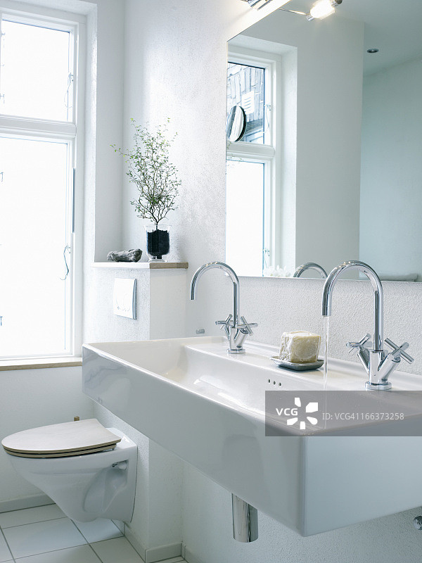 马桶旁边的双水龙头洗手盆图片素材